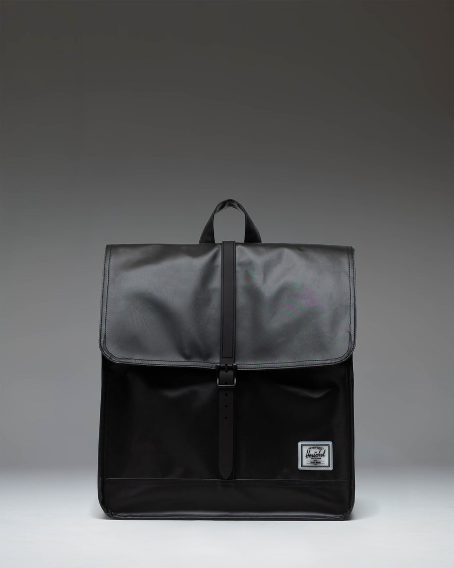 Herschel Supply Co. City Backpack in black, showing the clean, minimalist design with a single strap closure on the front pocket.