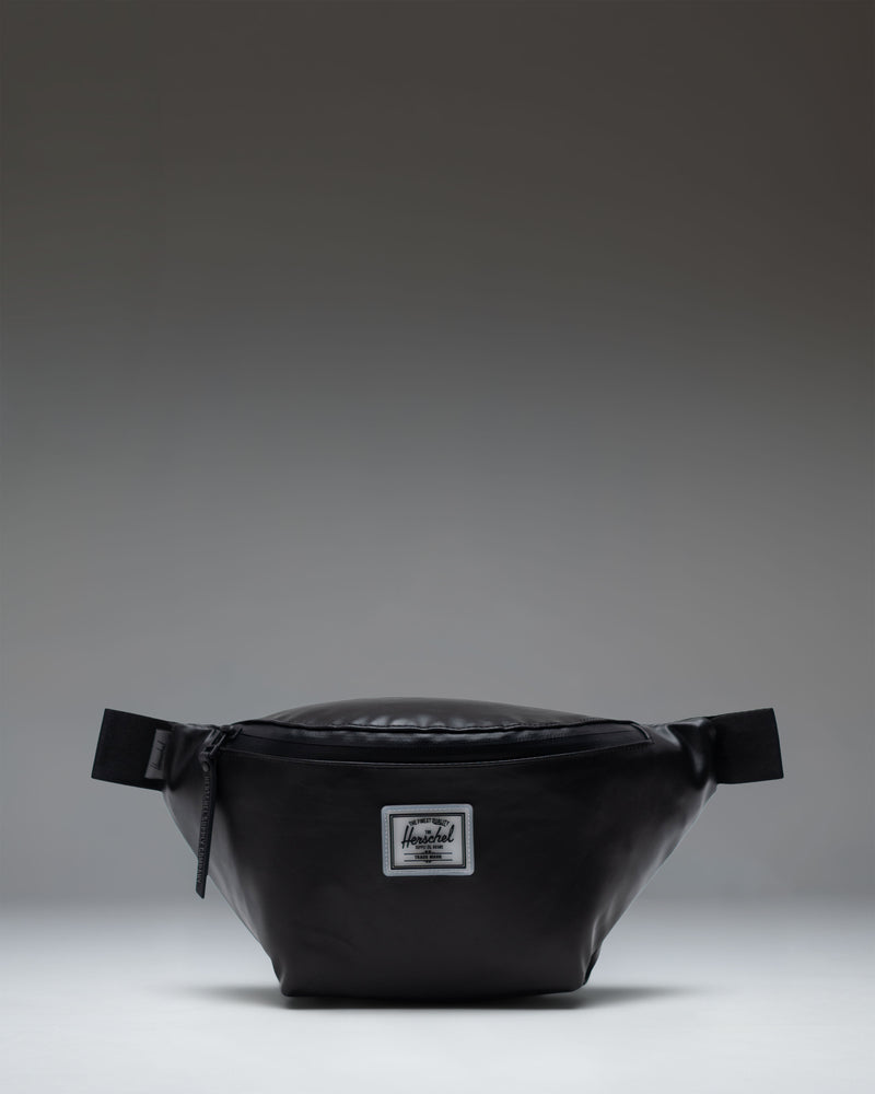 Herschel Supply Co. Pop Quiz Hip Pack in black shown from the front with a white logo patch.
