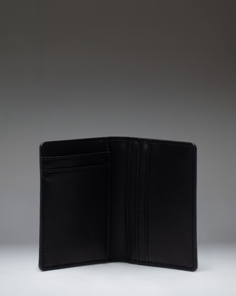 Black leather Herschel Supply Co Gordon Wallet open to show interior card slots and bill compartment.