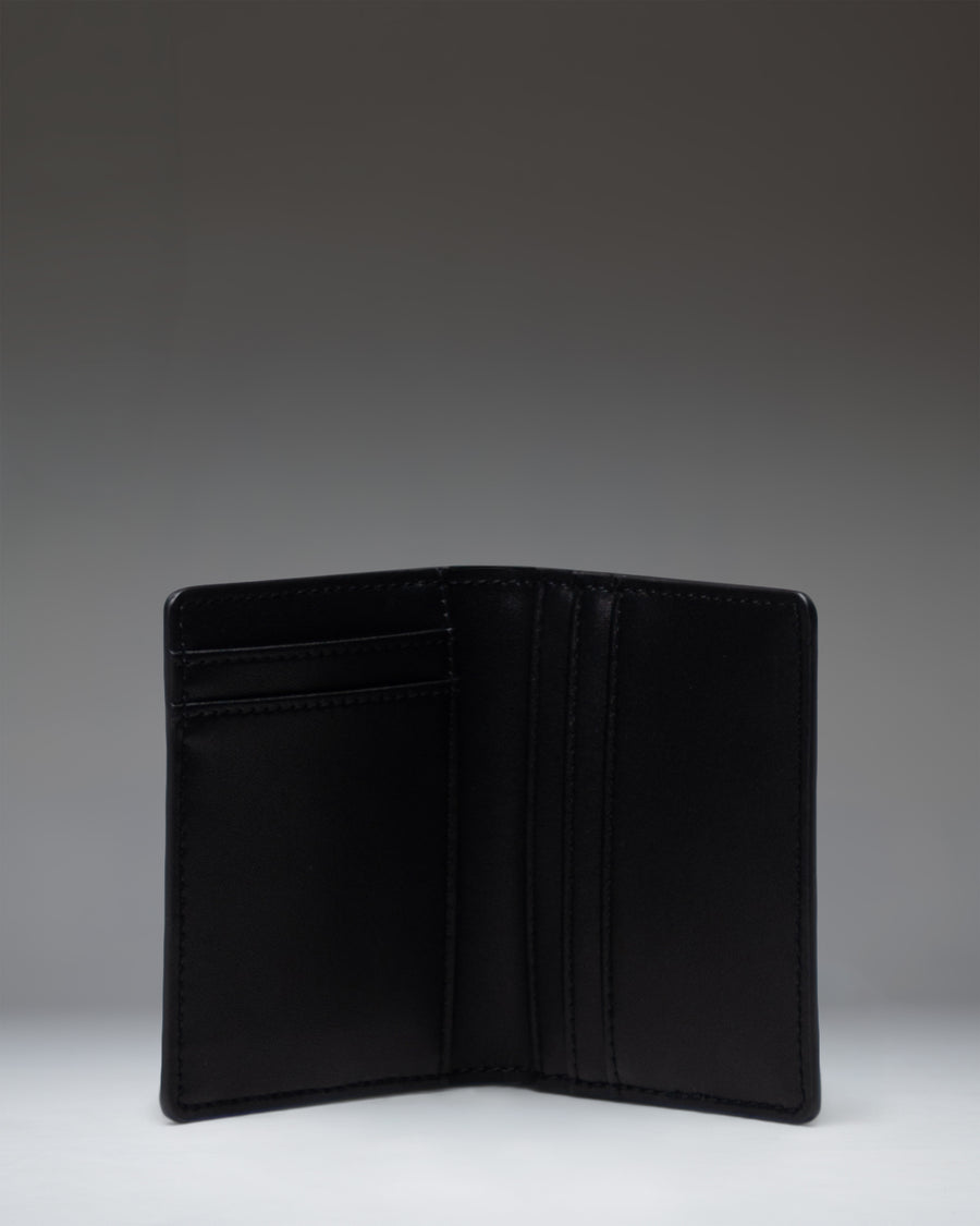 Black leather Herschel Supply Co Gordon Wallet open to show interior card slots and bill compartment.