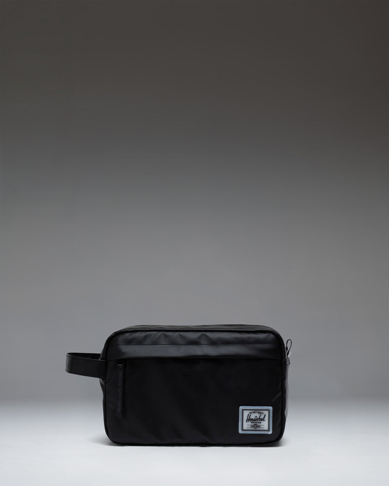Herschel Supply Co. Chapter Travel Kit in black, featuring a convenient side handle and a front zippered storage pocket.