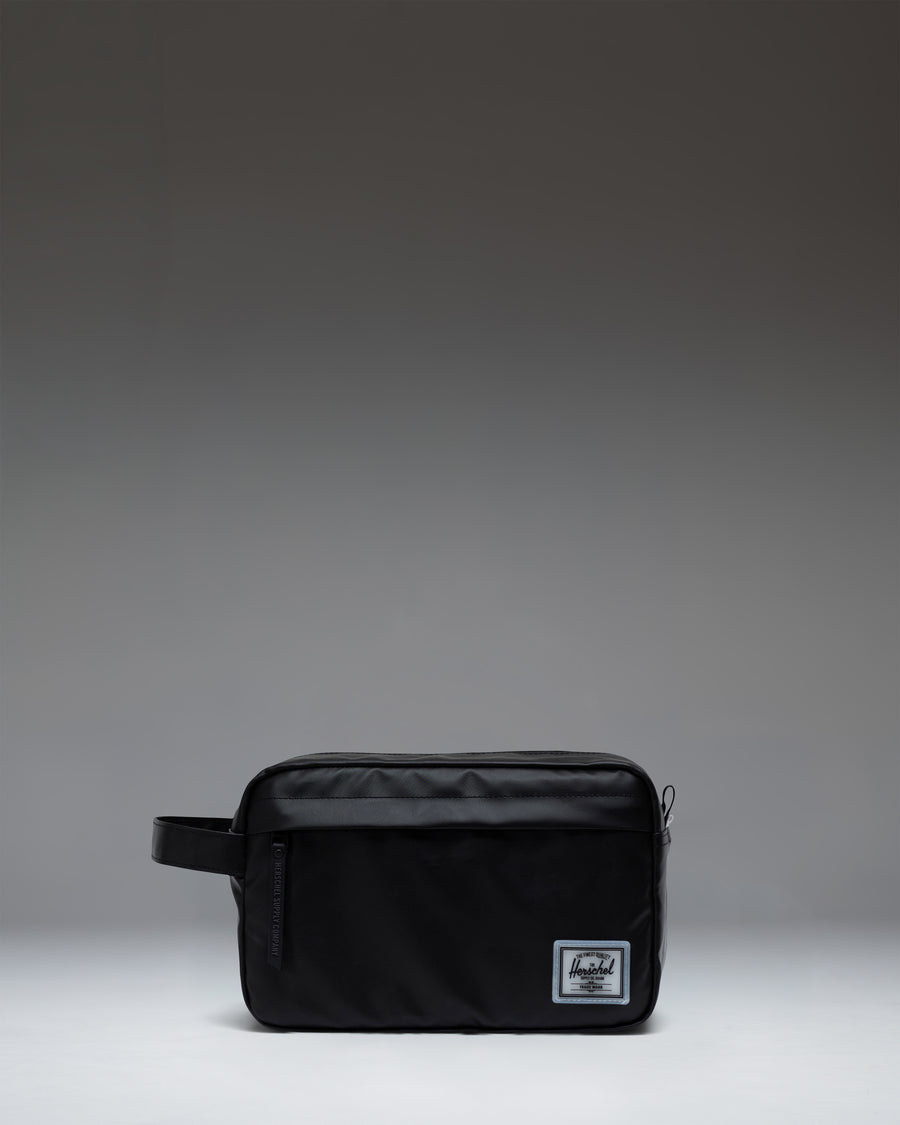 Herschel Supply Co. Chapter Travel Kit in black, featuring a convenient side handle and a front zippered storage pocket.