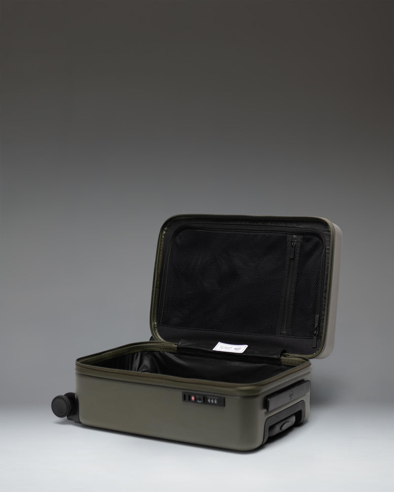 Herschel Heritage Hardshell Carry On Luggage in Ivy Green, showcasing a durable textured exterior, sturdy wheels, and a telescopic handle.