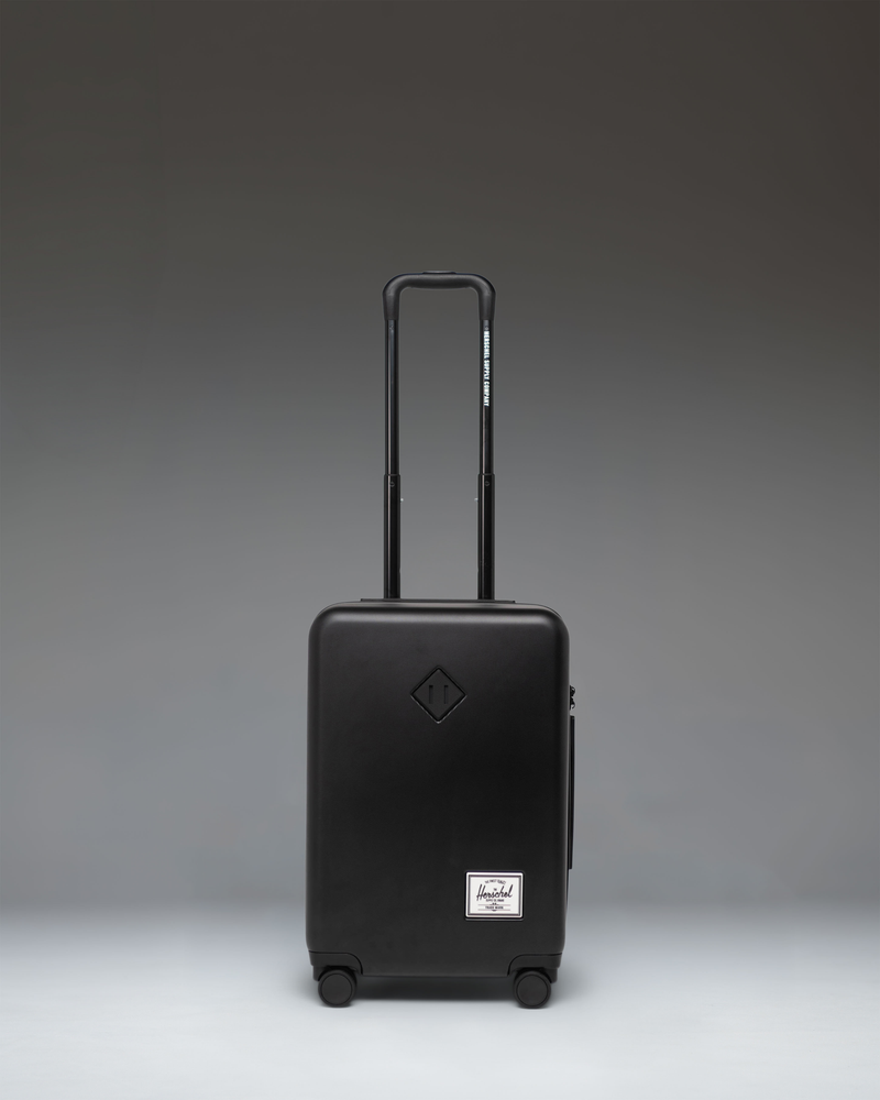 Black Herschel Heritage Hardshell Large CarryOn Luggage shown from the front against a white background.