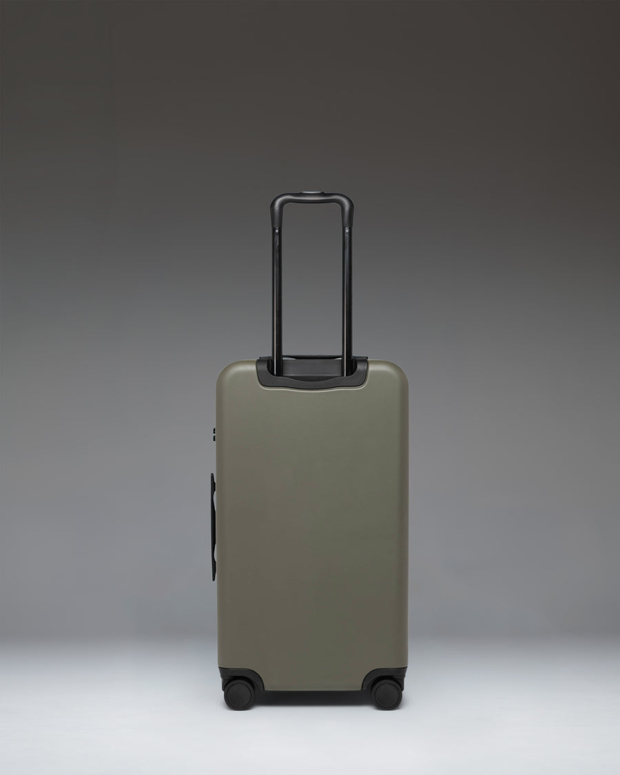 Herschel Heritage Hardshell Medium Luggage in Ivy Green shown from the side, highlighting its sleek design and durable construction.