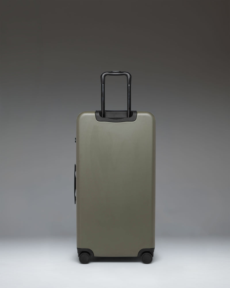 Herschel Heritage Hardshell Large Luggage in Ivy Green. Front view of the large green rolling suitcase with top and side handles.