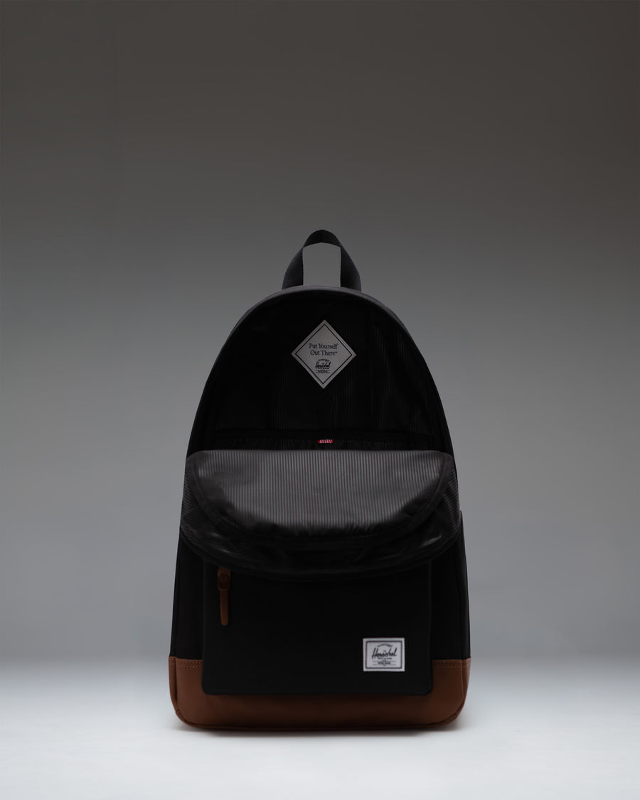 Herschel Heritage Backpack in Black/Tan, showcasing its classic design, signature diamond accent, and durable fabric canvas construction.