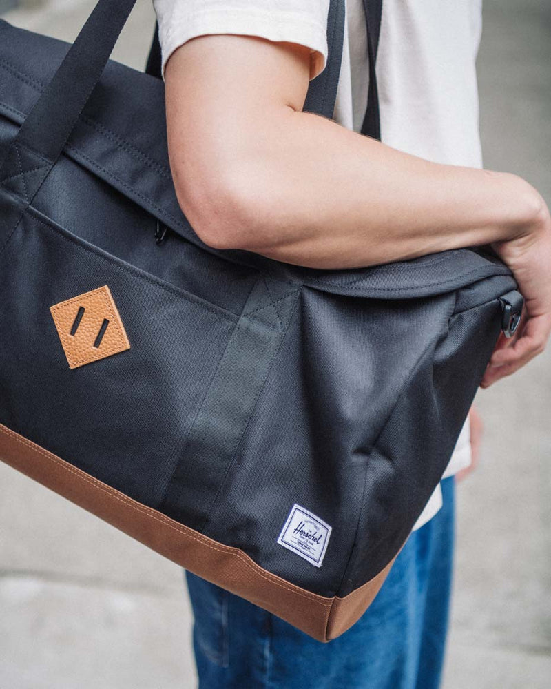 Herschel Supply Co. Heritage Duffle bags in various colors displayed together to showcase the classic design and available options.