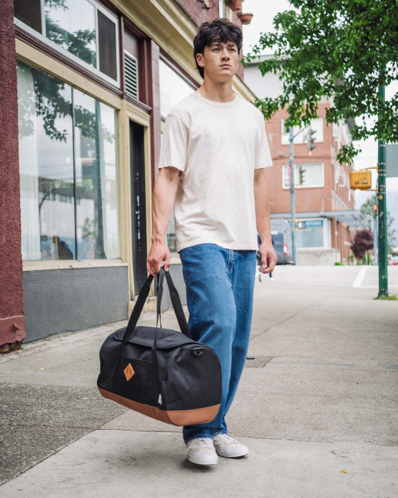 Herschel Heritage Duffle bag shown from multiple angles to highlight its U-shaped opening, top handles, and signature diamond detail.