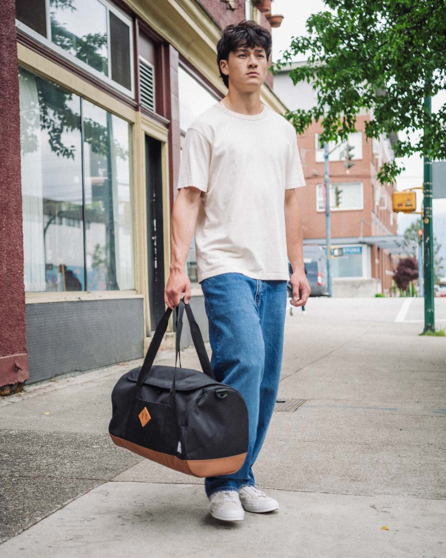 Herschel Heritage Duffle bag shown from multiple angles to highlight its U-shaped opening, top handles, and signature diamond detail.