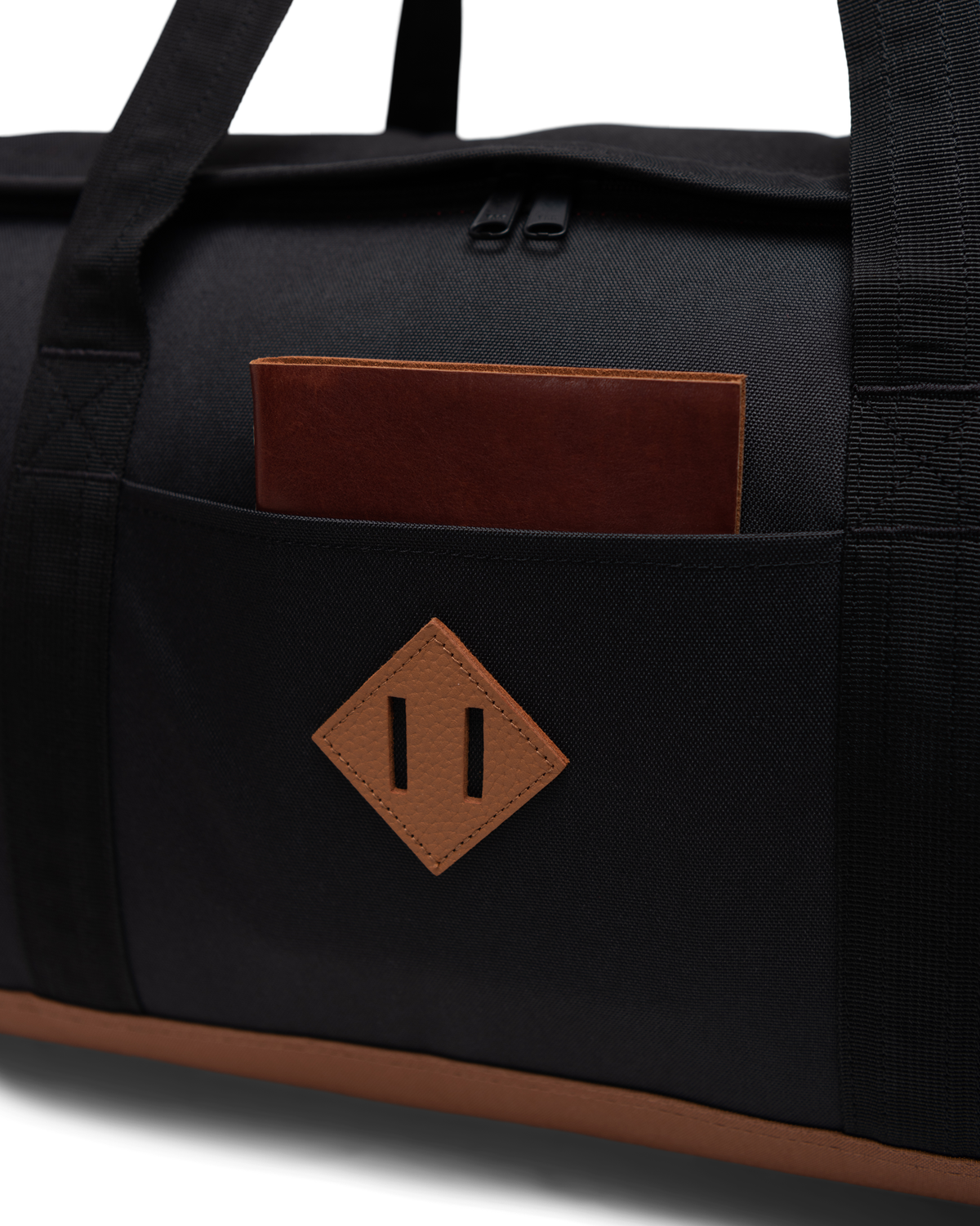 Herschel Heritage Duffle feature diagram highlighting the U-shaped opening, top handles, front sleeve, and removable shoulder strap.