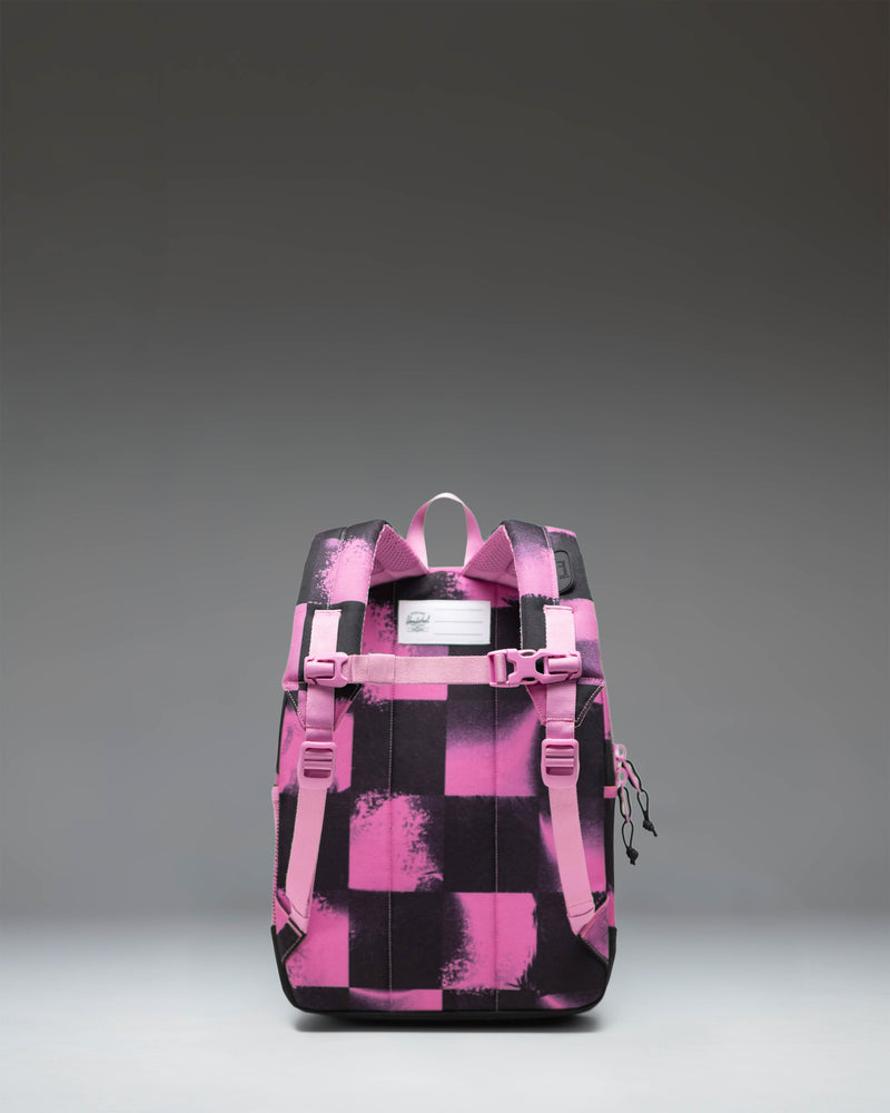 Herschel Heritage Kids Backpack in Stencil Checker Opera Mauve, featuring a pink and white checkered pattern with a front pocket and rubber diamond.