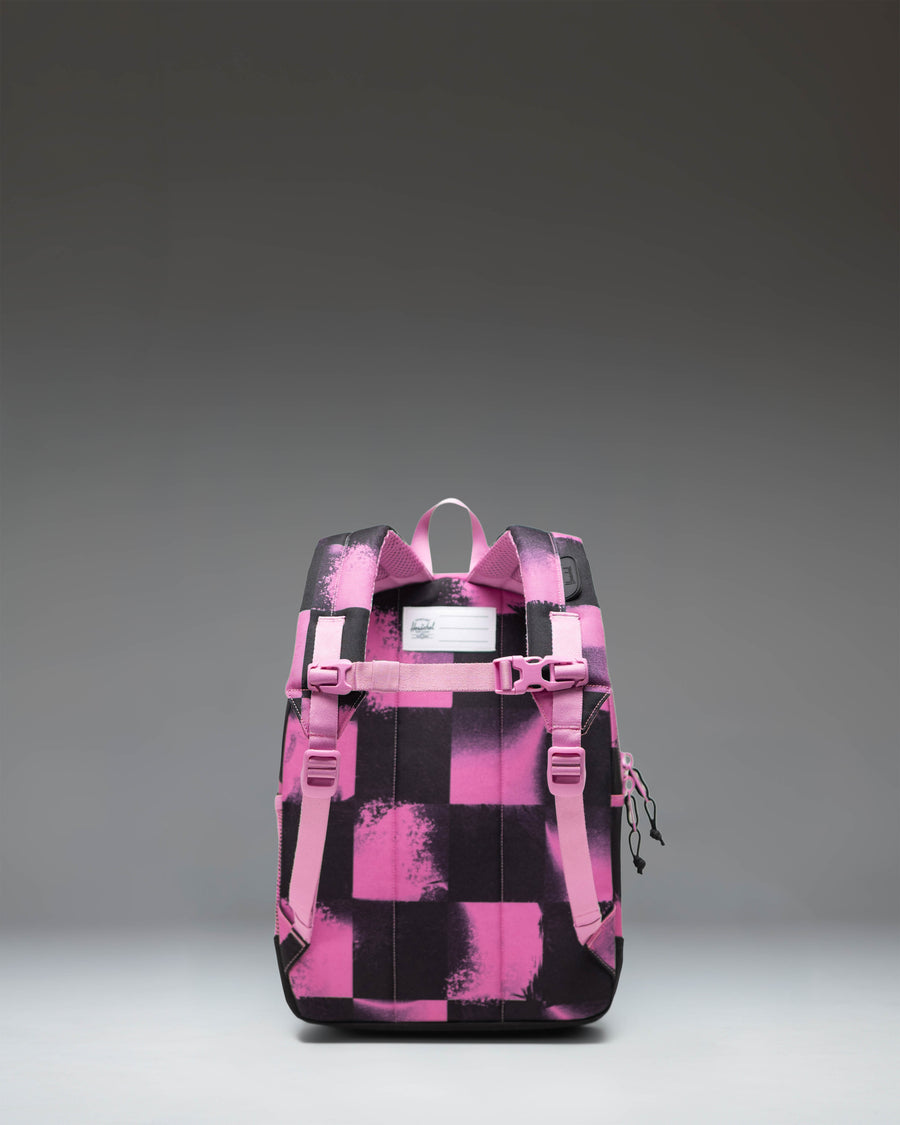 Herschel Heritage Kids Backpack in Stencil Checker Opera Mauve, featuring a pink and white checkered pattern with a front pocket and rubber diamond.