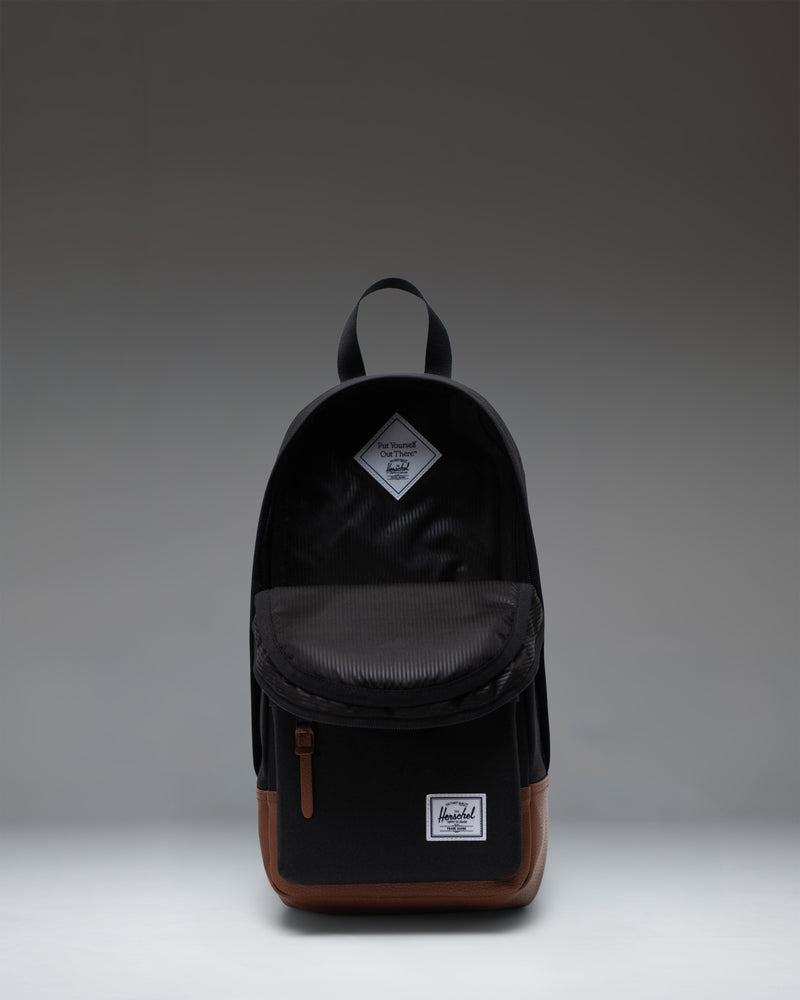 Herschel Heritage Shoulder Bag in Black/Tan being worn across the body of a person to show size and scale.