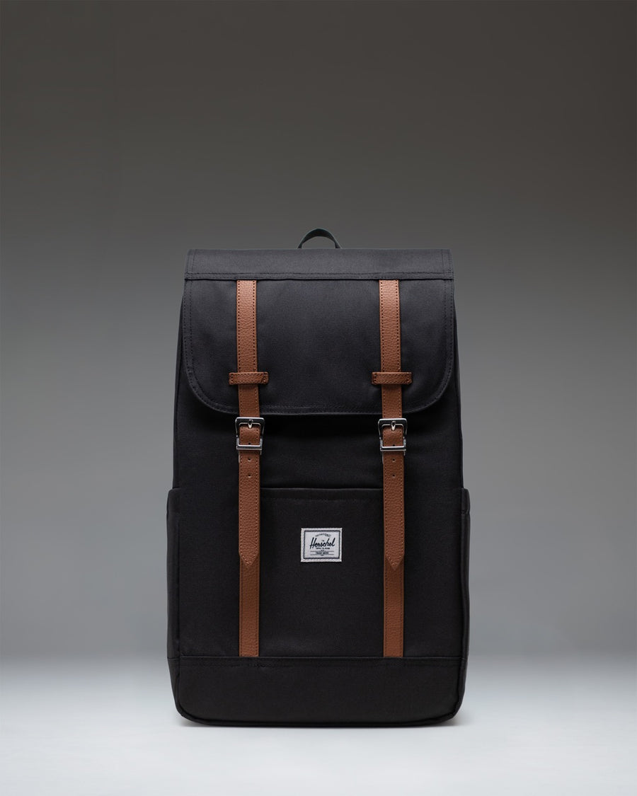 Black Herschel Retreat Backpack featuring a classic cinch top design, dual magnetic strap closures, and a front storage sleeve.