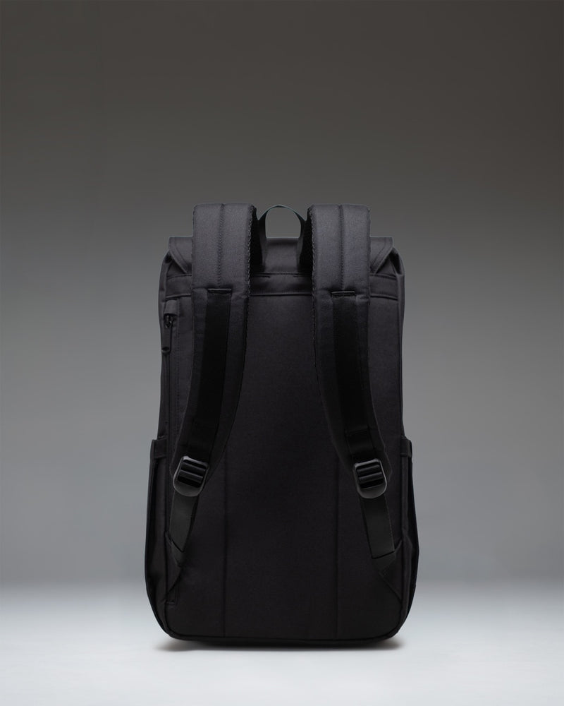 Black Herschel Retreat Backpack featuring a clean, cylindrical design with dual rubber straps, a magnetic closure, and a woven logo label.