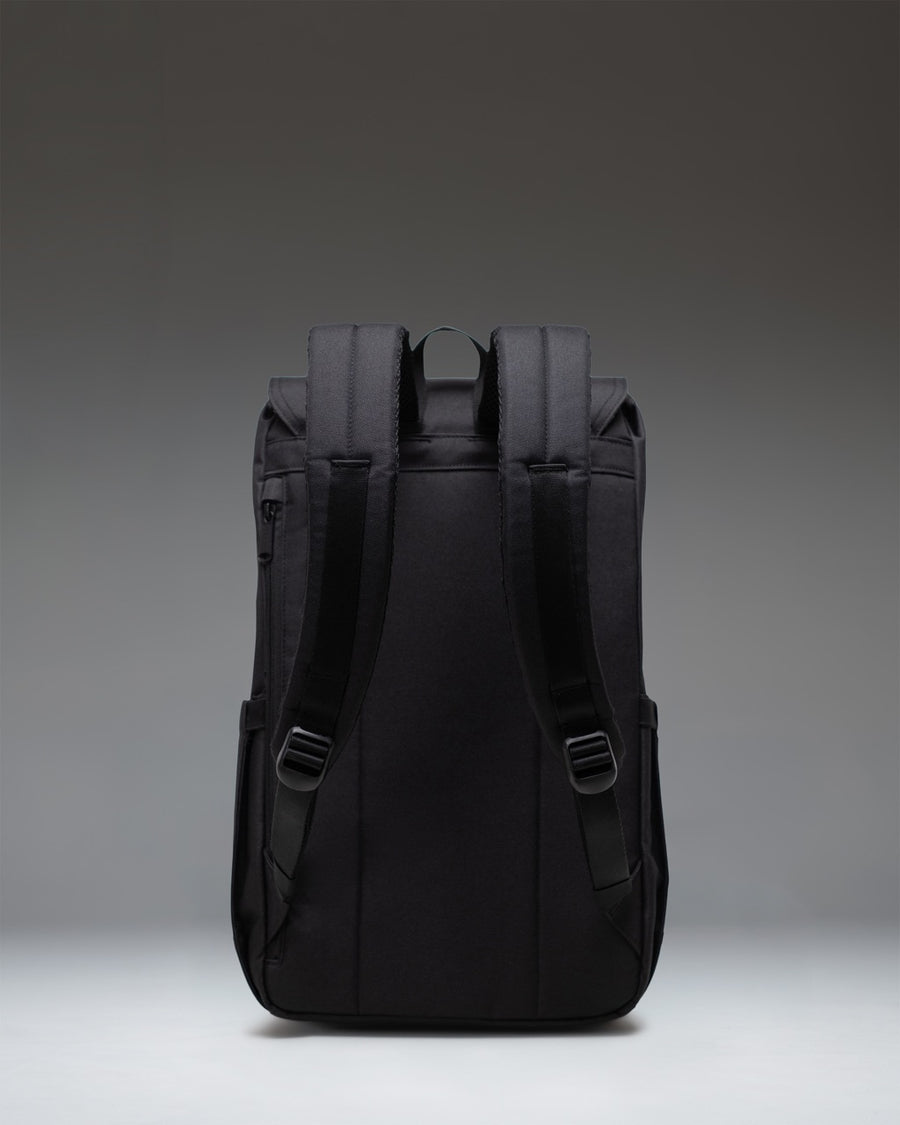Black Herschel Retreat Backpack featuring a clean, cylindrical design with dual rubber straps, a magnetic closure, and a woven logo label.