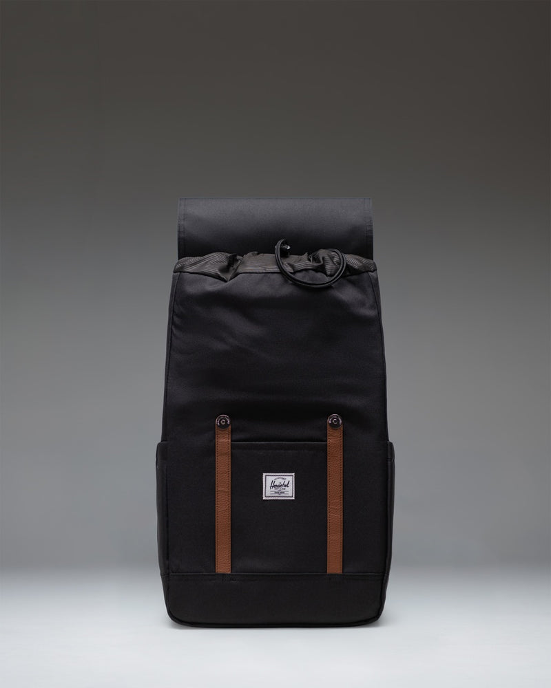 Classic Herschel Retreat Backpack in black, featuring a clean cylindrical design with magnetic strap closures and a woven label.