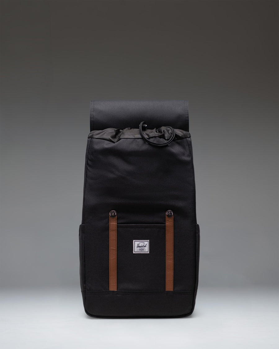 Classic Herschel Retreat Backpack in black, featuring a clean cylindrical design with magnetic strap closures and a woven label.