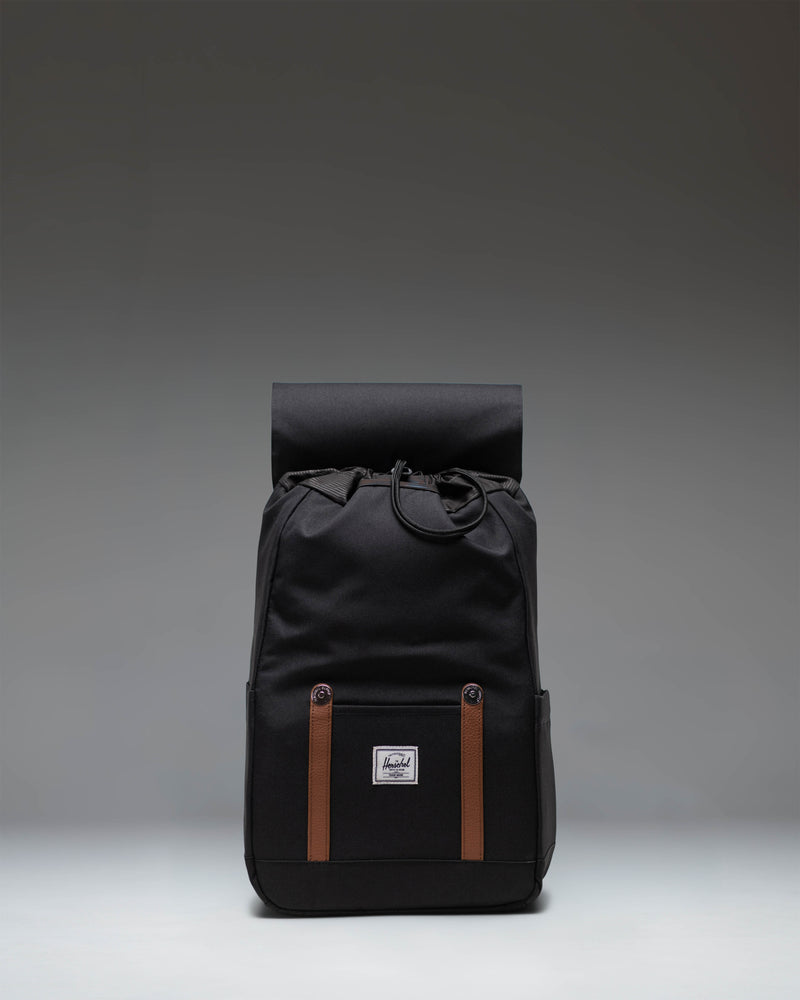 Herschel Retreat Small Backpack in black, featuring a classic cinch-top closure, front storage sleeve, and magnetic strap closures.
