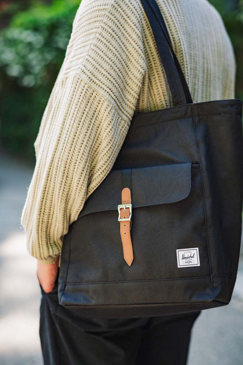 A collection of Herschel Supply Co. Retreat Totes displayed together in a variety of colors and patterns.