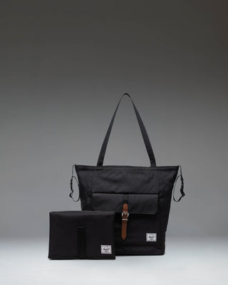 Black Herschel Retreat Tote Diaper Bag shown from the front, highlighting its clean design, shoulder straps, and iconic woven label.