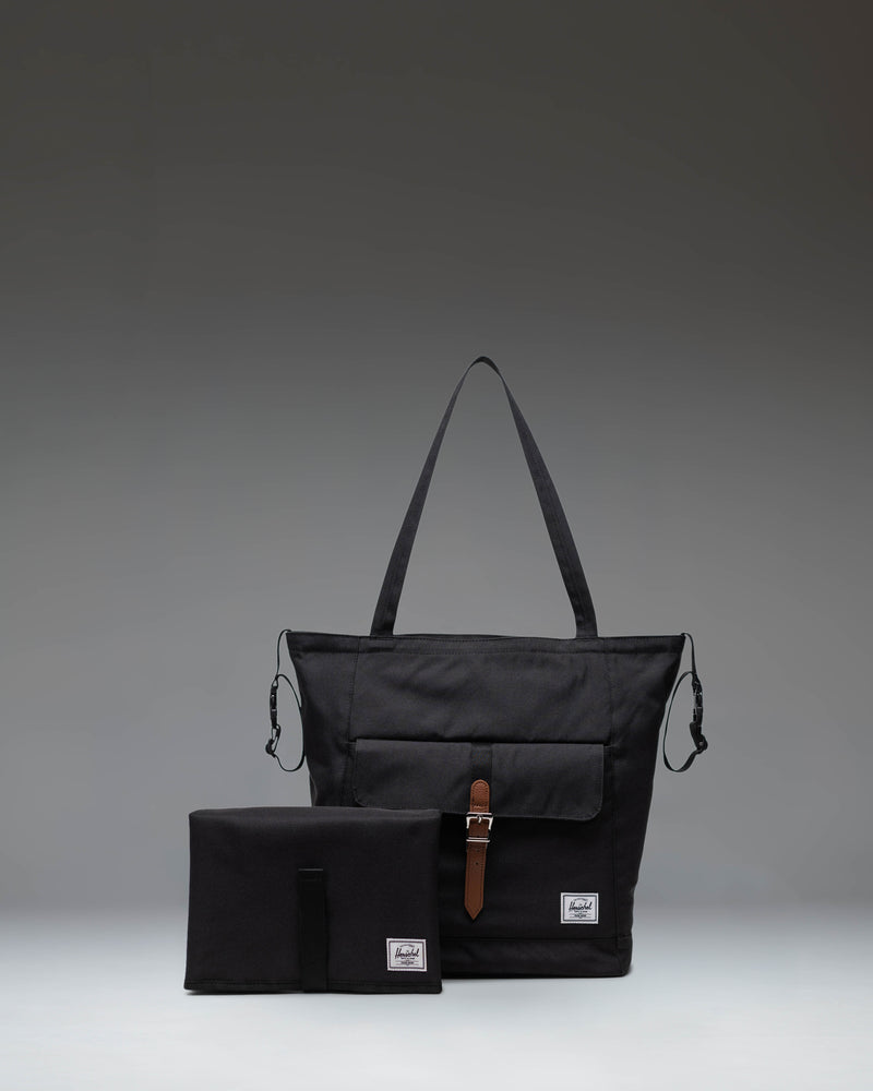 Black Herschel Retreat Tote Diaper Bag shown from the front, highlighting its clean design, shoulder straps, and iconic woven label.