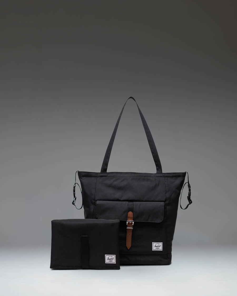 Black Herschel Retreat Tote Diaper Bag shown from the front, highlighting its clean design, shoulder straps, and iconic woven label.