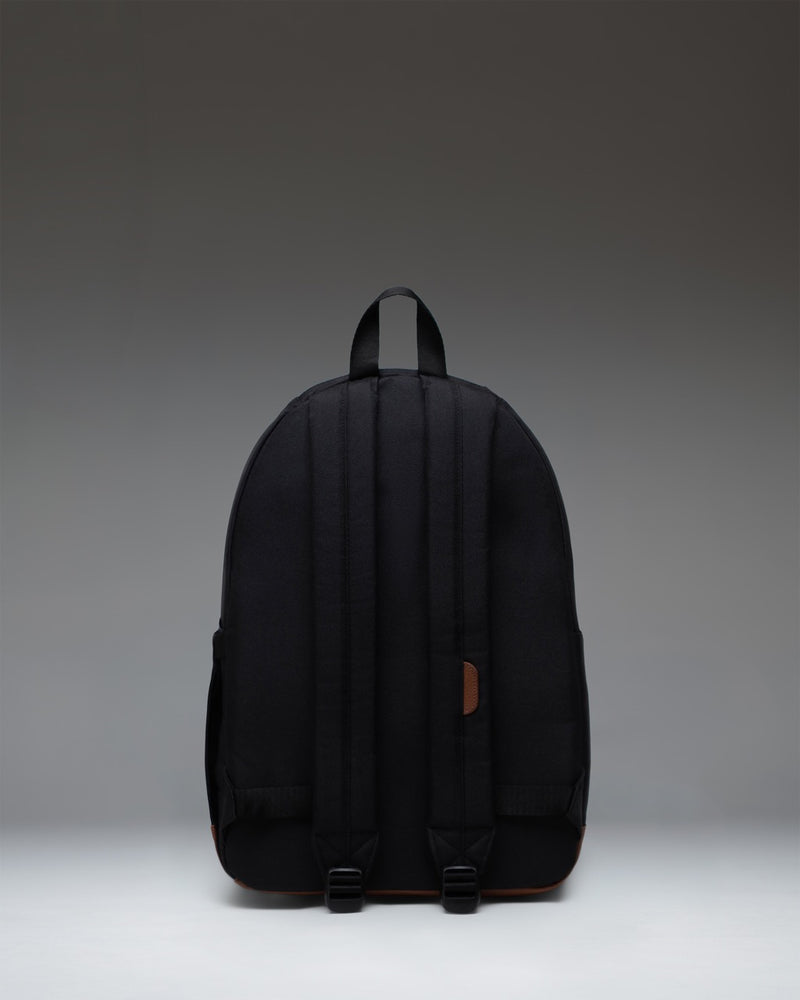 Herschel Supply Co. Pop Quiz Backpack in Black featuring a tan synthetic leather bottom and front pocket detail.