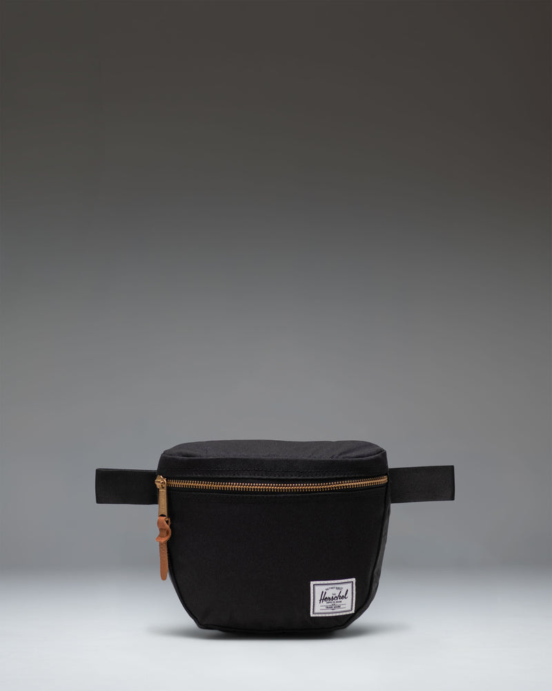 Herschel Supply Co. Settlement Hip Pack in black shown from the front, highlighting its clean design and classic woven label.