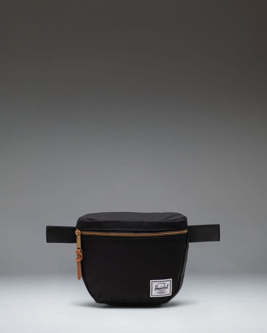 Herschel Supply Co. Settlement Hip Pack in black shown from the front, highlighting its clean design and classic woven label.