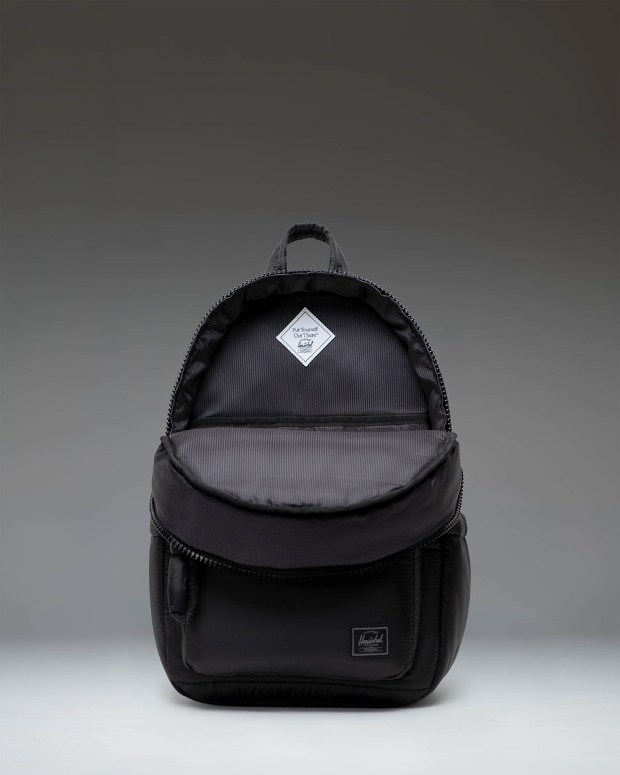 Herschel Supply Co. Settlement Backpack in classic black, featuring a front storage pocket, exposed zippers, and the signature woven label.