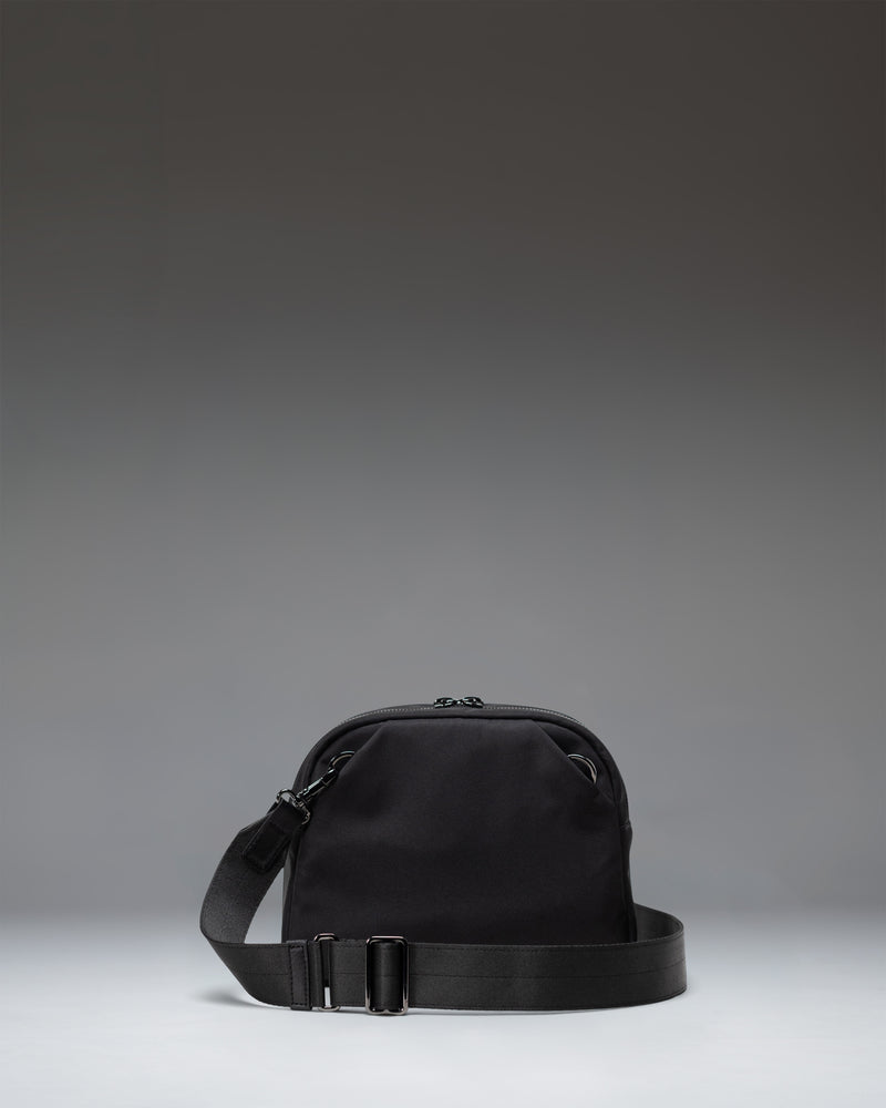 Black Herschel Supply Co. Thalia Crossbody bag featuring a sleek, minimalist design with an adjustable shoulder strap.