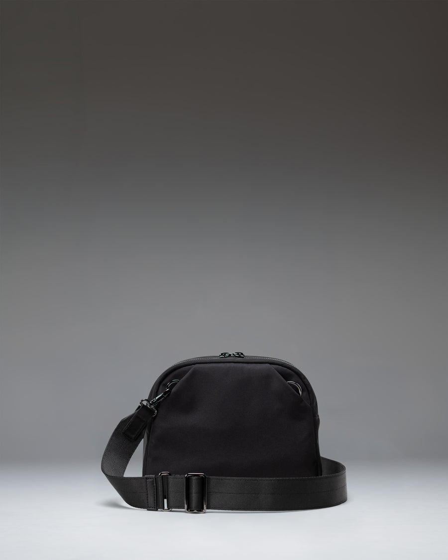 Black Herschel Supply Co. Thalia Crossbody bag featuring a sleek, minimalist design with an adjustable shoulder strap.