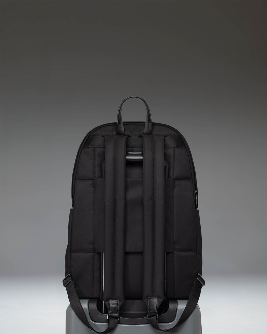 Herschel Supply Co. Beatrix Backpack in solid black, showing a detailed close-up of the front zipper pocket and classic woven label.