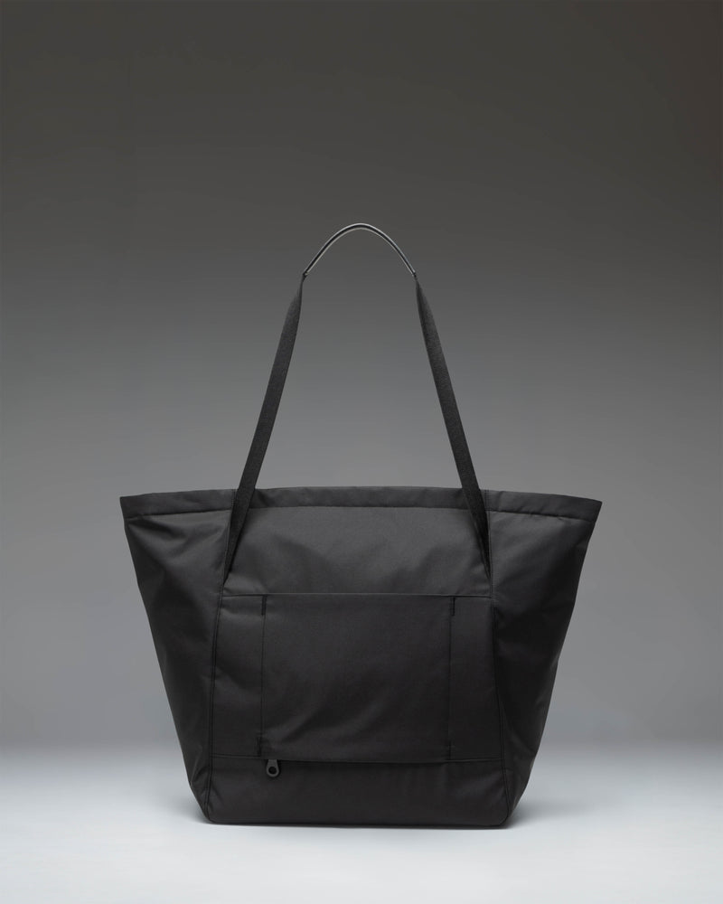 Herschel Supply Co. Joana Tote in black featuring structured recycled twill fabric, a front zippered pocket, and dual shoulder straps.