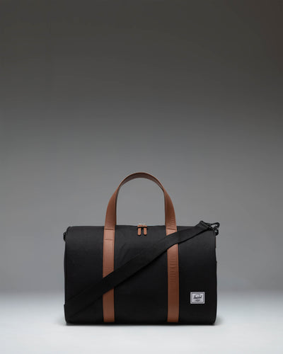 Herschel Novel Carry On Duffle in black, showing the classic side profile with the signature shoe compartment zipper.