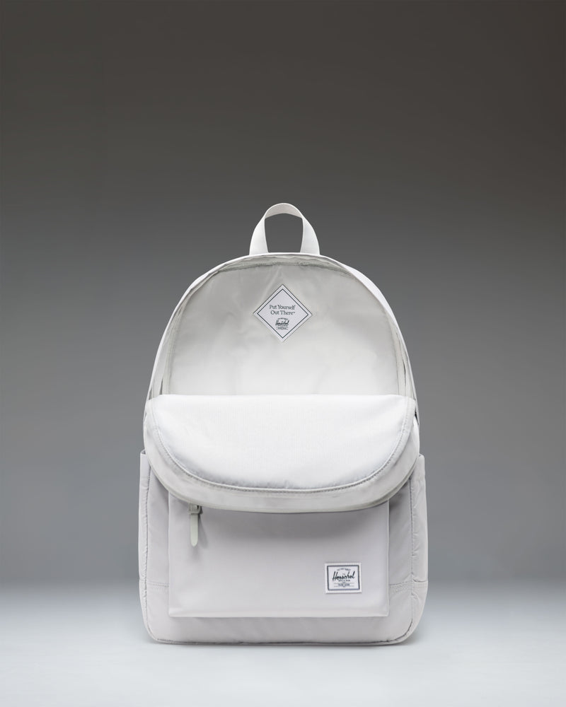 Herschel Supply Co. Heritage collection backpack in Metal color worn by a child standing in front of a white background.