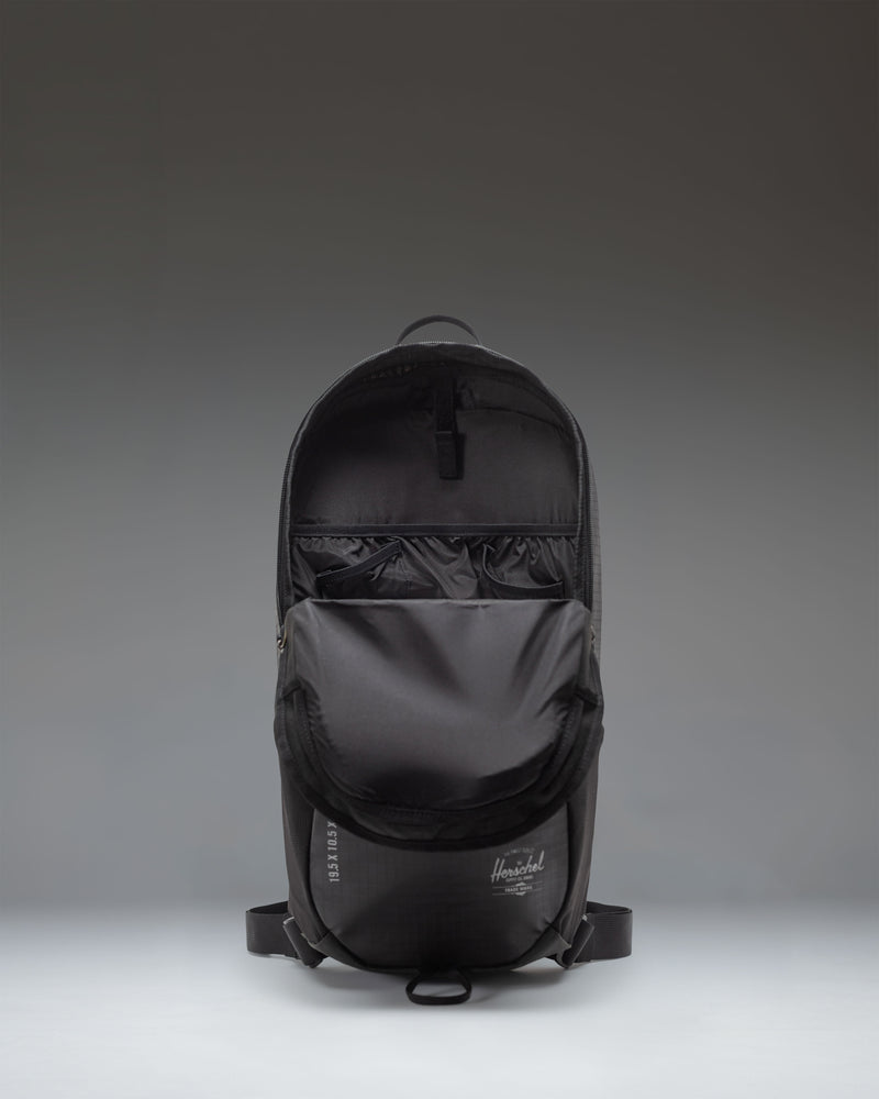 Herschel Supply Co. All Season Backpack 17 L in black, showing a lifestyle view of the backpack being worn outdoors.