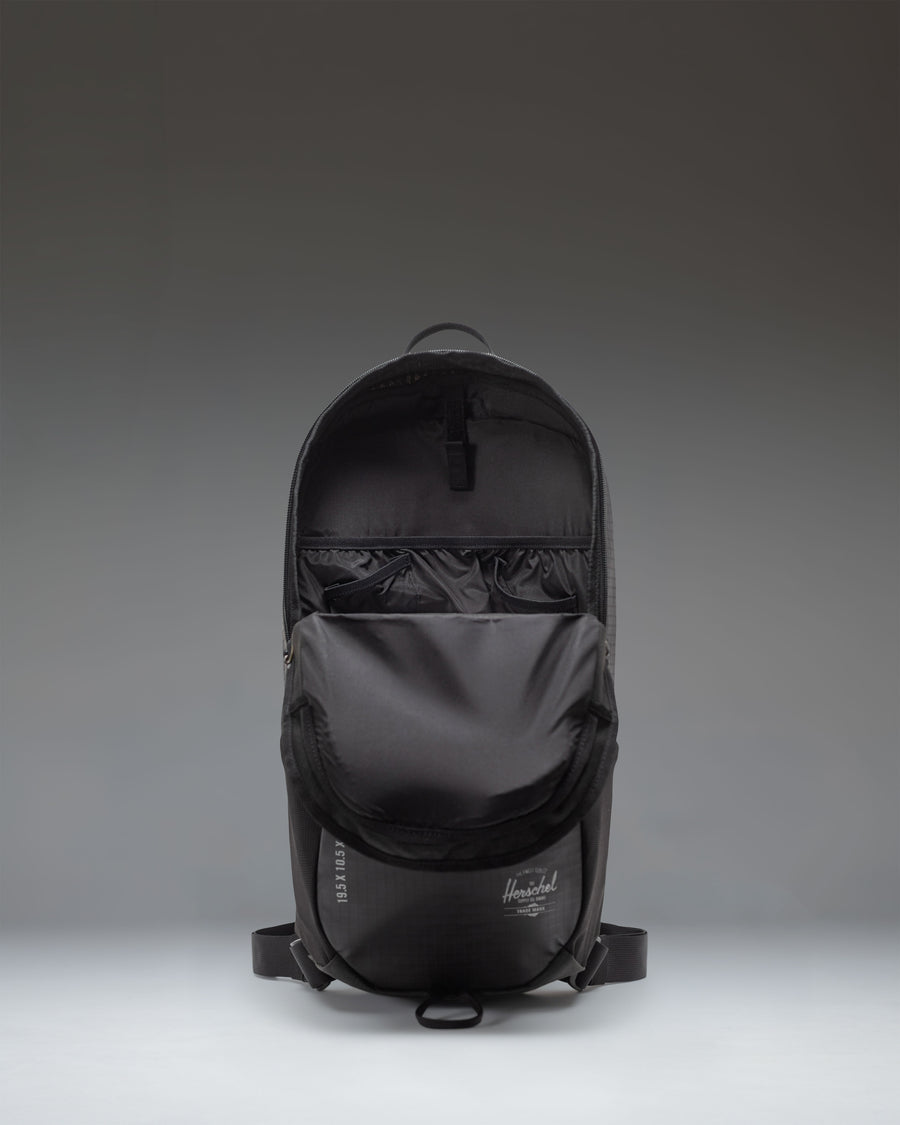 Herschel Supply Co. All Season Backpack 17 L in black, showing a lifestyle view of the backpack being worn outdoors.