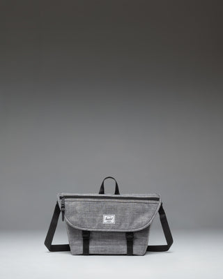 Herschel Supply Co. Cove Small Messenger bag in Raven Crosshatch grey, showing a front view with a flap closure, handle, and adjustable shoulder strap.