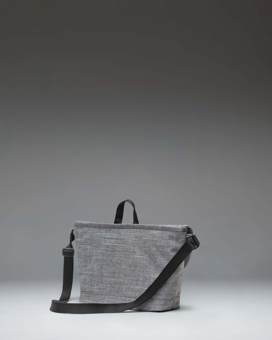 Herschel Supply Co. Cove Small Messenger bag in Raven Crosshatch grey, showing a front view with the flap closed and buckle detail.