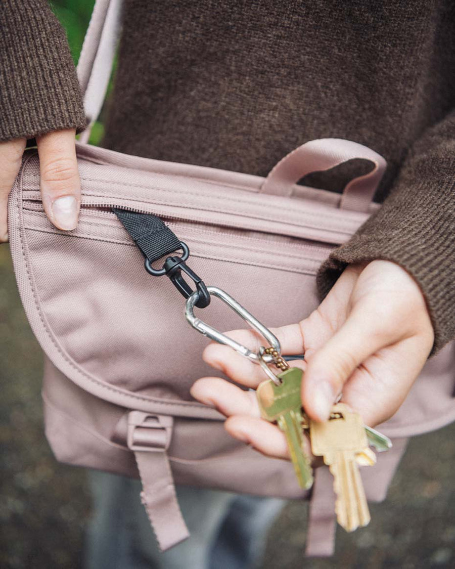 Herschel Supply Co. Cove Small Messenger bag in a green camo pattern, shown from the front with two buckle straps.
