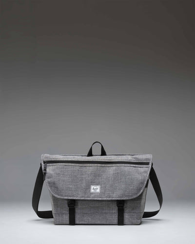 Herschel Supply Co. Cove Messenger bag in Raven Crosshatch grey, showing the front flap, buckle closure, and shoulder strap.