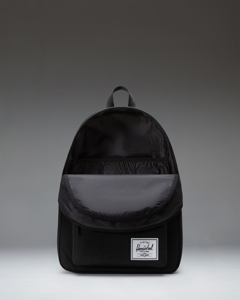 Herschel Supply Co. Classic XL black backpack showing a durable polyester design with a spacious front pocket and zippered closure.