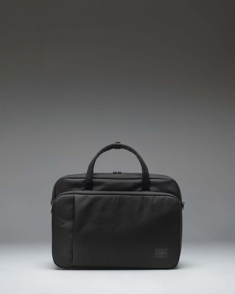 Herschel Supply Co. Gibson Messenger Tech bag in black, showing the front view with dual top handles, a removable shoulder strap, and front pockets.