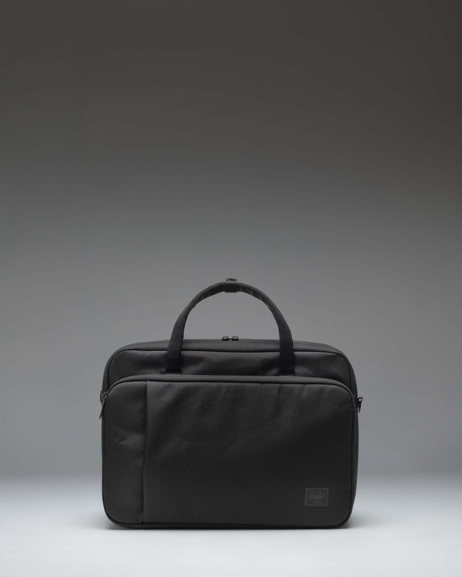 Herschel Supply Co. Gibson Messenger Tech bag in black, showing the front view with dual top handles, a removable shoulder strap, and front pockets.