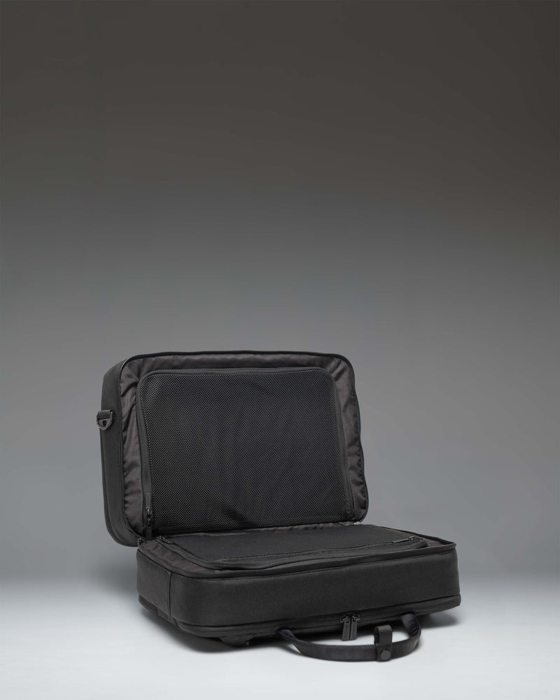Herschel Supply Co. Bowen Convertible Travel Duffle Tech bag in black, showing the back panel with a zippered luggage trolley sleeve.