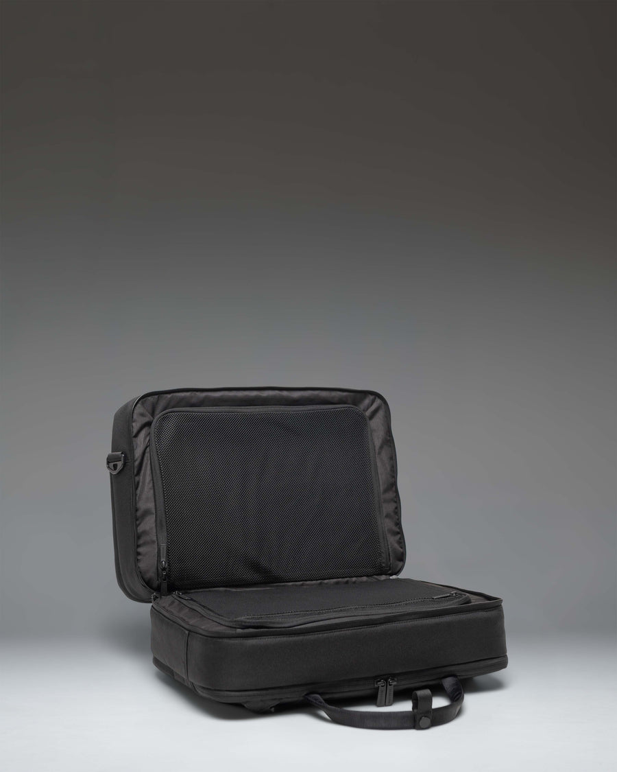 Herschel Supply Co. Bowen Convertible Travel Duffle Tech bag in black, showing the back panel with a zippered luggage trolley sleeve.