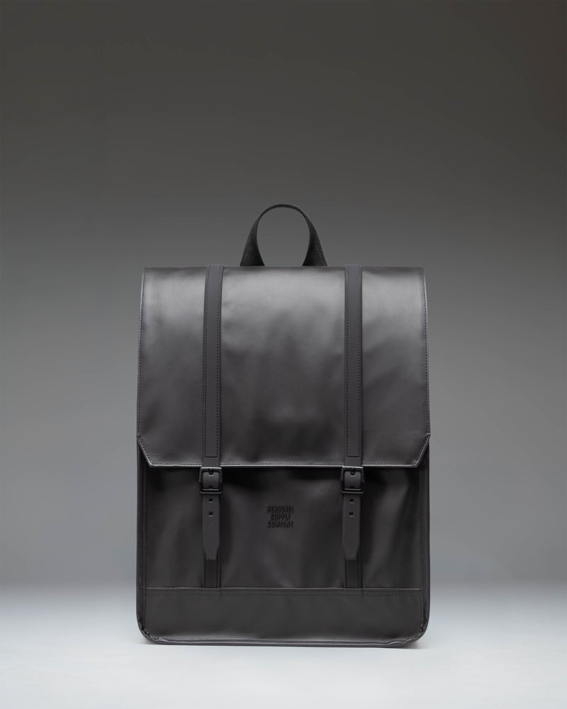 Herschel Survey Backpack in black, showing the front view with its classic square silhouette and dual strap closures.
